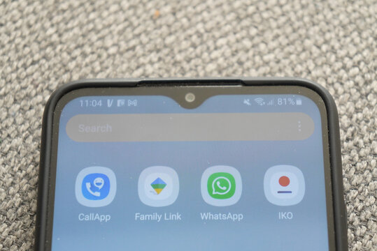 Smartphone screen displaying apps and search bar, close-up shot