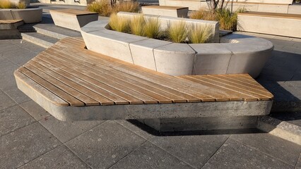 Stylish Bench Amid Urban Greenery, Urban Space Featuring Wooden Seating With Geometric Shadow Patterns © my1px