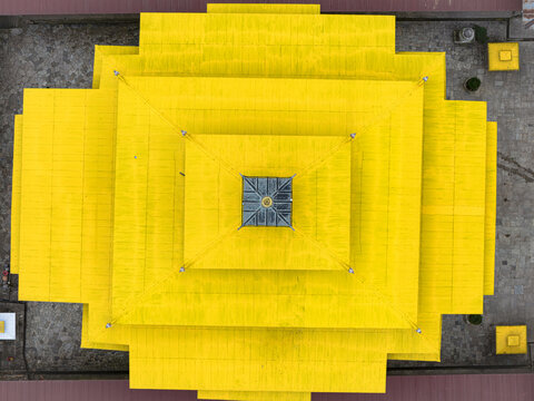 Aerial view of the radiant yellow rooftops of Gangtey Monastery layered like a tiered cake, standing out against the muted landscape, Gangtey Monastery, Phobjikha valley, Bhutan.
