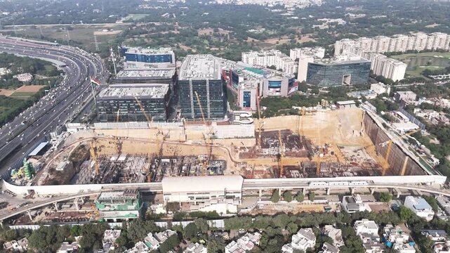 Drone video of DLF Downtown, highlighting high-rise corporate blocks, Metro Train, active construction zones, and the fast-moving New Delhi-Jaipur motorway defining Gurugram&rsquo;s urban expansion.