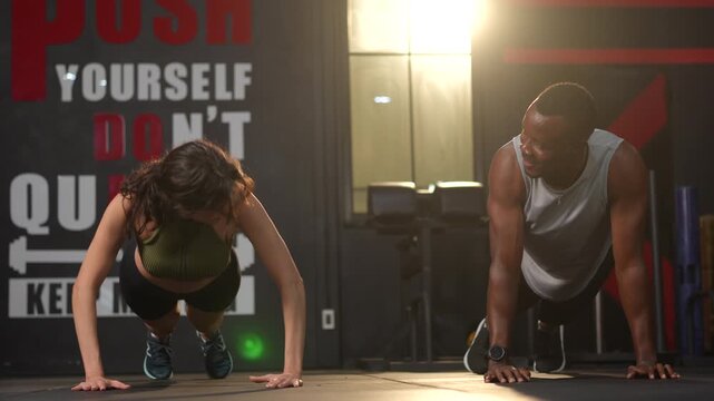 Fit couple gym workout plank high five motivation training athlete teamwork happiness intense fitness pushup exercise determination strength discipline focused athletes doing push up on gym floor