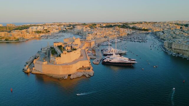 Epic aerial panorama of Fort St. Angelo in Birgu, historic medieval limestone fortress in the Grand Harbour of Valletta, Malta, cinematic 4k drone