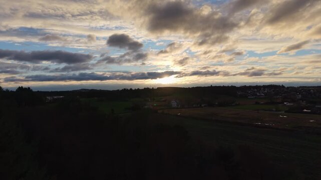 A drone aerial focused on a blue sky partially covered by soft, scattered clouds. The view emphasizes the atmosphere rather than the ground, showcasing gentle cloud formations, subtle light variations