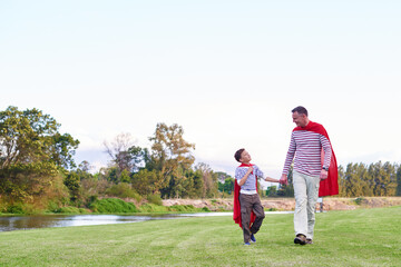 Holding hands, superhero and father with child in nature for cosplay, bonding or family time....