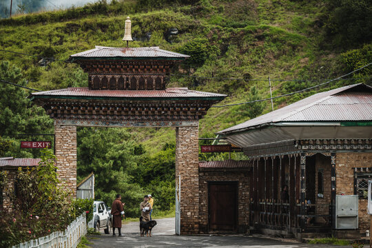 Paro, Bhutan - 17 September 2025: View of the National Museum's entrance gate, with intricate woodwork contrasting against the stone, framed by the green hills.