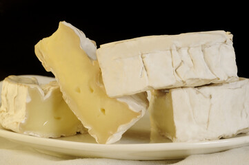 Slices of Camembert cheese on white plate