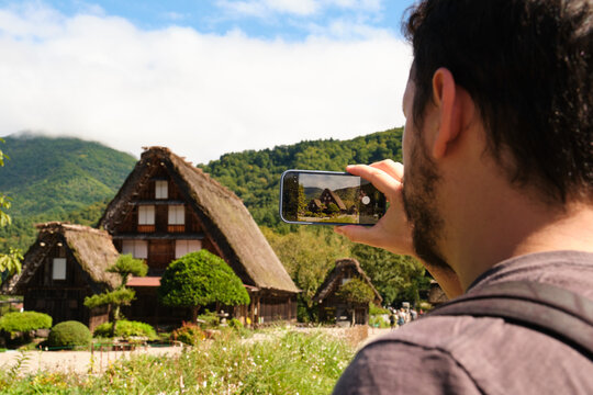 Tourist capturing traditional Japanese gassho zukuri houses in Shirakawa go, Japan