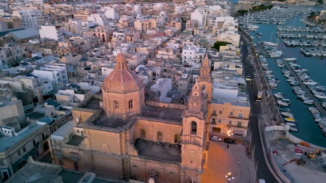 Aerial 4K view of the Msida Parish Church and yacht marina at sunset, Malta
