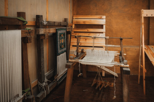 Chumey, Bhutan - 23 September 2025: View of a traditional wooden loom with white and green woven fabrics, showcasing the artistry of Bhutanese textile craftsmanship.