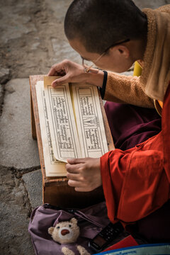 Walakha, Bhutan - 19 September 2025: View of a nun at Sangchhen Dorji Lhuendrup Lhakhang Nunnery absorbed in ancient texts, a stark contrast to the modern world.