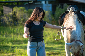 Young female equestrian enjoying with horse in farm