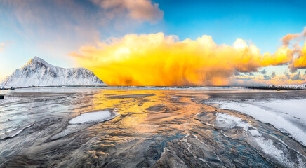 Astonishing winter scenery on Skagsanden beach with illuminated clouds during sunrise. © pilat666