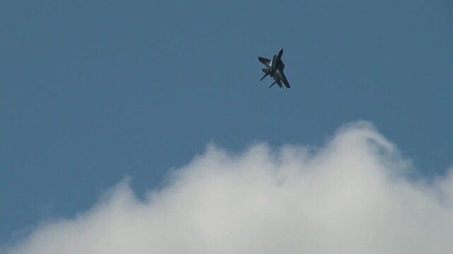 American all-weather F-15 Eagle fighter performs aerobatics with vertical climb against blue in white clouds of sky. Zhukovsky, Russia, August 18, 2011. 
