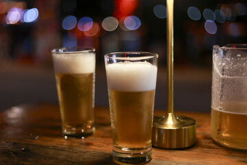 Two glass of cold draft beer with foam on wooden table at bar. This relaxing alcohol beverage perfect drink for celebration or fun night out with friends
