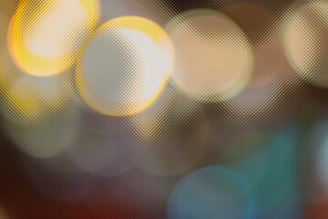 Abstract soft golden and grey bokeh lights through textured glass. Elegant blurred city background.