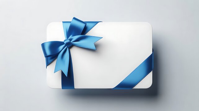 A white gift card or voucher wrapped with a bright blue satin ribbon and a neat bow, isolated on white background - Powered by Adobe