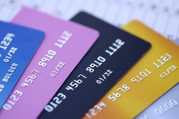 Many credit or debit cards with fictional specimen numbers on business calculations document. Big amount of banking plastic cards of various colors. Financial concept of business and e-commerce