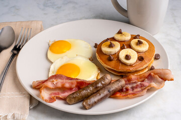 fried eggs with pancakes  , sausage and bacon