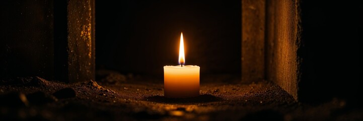A single candle burning brightly in a dark, mysterious setting
