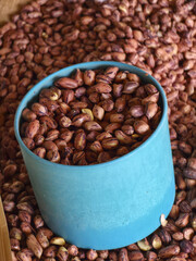 Wholesome roasted peanut snack in blue cup full of brown food. natural protein ingredient for healthy diet, providing good nutrition in simple pile