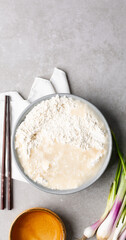 Overhead view of scallion pancake dough being mixed in a grey bowl, top view of cong you bing dough being mixed, process of making scallion pancakes
