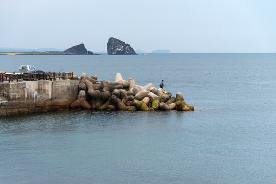 idyllic seascape with jetty and rocks at Songaksan in Jeju Island, South Korea