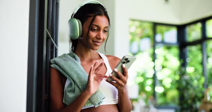 Home, headphones and woman with fitness, smartphone and listening to music, app and subscription. Audio streaming, cellphone and person with break, exercise or podcast for workout motivation or sound