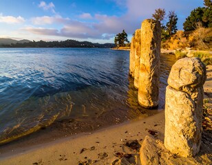 Sun-drenched coastal scene with weathered stone posts