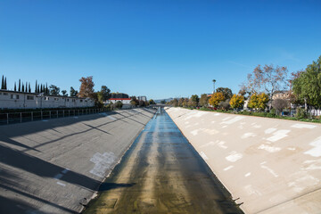 Photograph of the Los Angeles river in the Canoga Park neighborhood of Los Angeles California.   Generative fill AI edit was used to remove overhead wires.