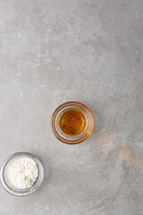  overhead view of flour and oil In a glass bowl on cement countertop,  top view of flour and oil for making a roux, Process of the making of a roux