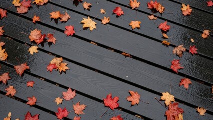 Autumn Leaves Scattered on Dark Wooden Decking in a Serene Outdoor Setting.