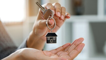 Hand Holding House Key - New Home Ownership Concept