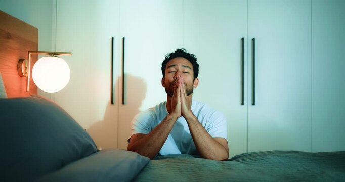 Man, praying and religion in bedroom, night and worship with routine, connection and talk with God in home. Spiritual person, faith and gratitude by bed, tired and Christian belief at apartment