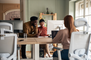 Obraz premium Diverse Team Collaborating in Modern Office Environment on Creative Project