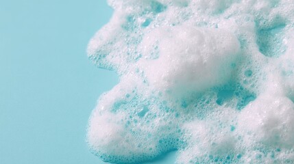 Fototapeta premium White foam spreads over a blue surface during a cleaning activity