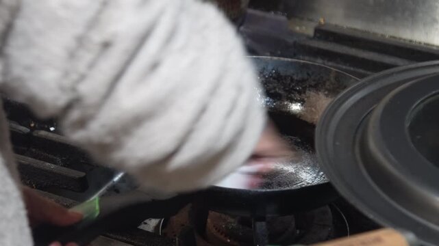 フライパンに油を塗る女性