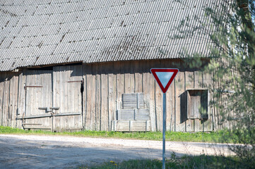 Old Wooden Barn and Yield Sign in Spring Light