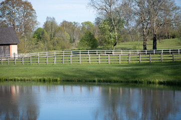 Rustic Fence Beside Quiet Latvian Countryside Pond
