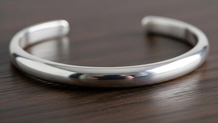 Elegant silver bracelet displayed on a dark wood surface