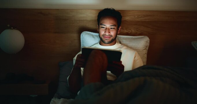 Evening, bedroom and man with tablet, reading and search for funny blog, humor and ebook. Doom scroll, night or person with tech, laughing or blue light exposure with app for social media or home