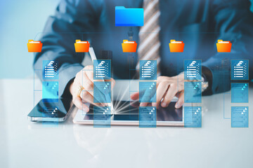 A professional's hand interacts with digital projecting document icons and a folder, symbolizing advanced file management and digital organization. Document Management System concept. Online document.