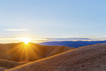 Serene sunset over rolling hills creates peaceful atmosphere, highlighting beauty of nature and transition of day to night