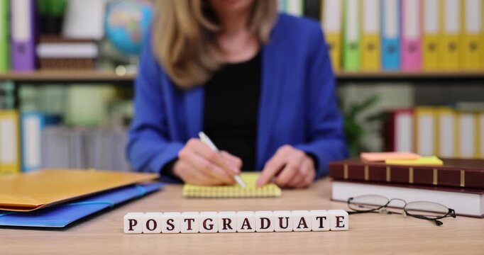 Focused student diligently preparing for postgraduate studies with notes and documents on a colorful desk at a bright, academic setting