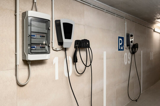 Fototapeta EV Charger Station and Electricity Meter for EV Charging for Personal Apartment in Urban Underground Car Parking Basement of Smart Apartment Building.