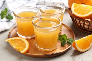 Fresh orange juice, mint and fruits on light table, closeup