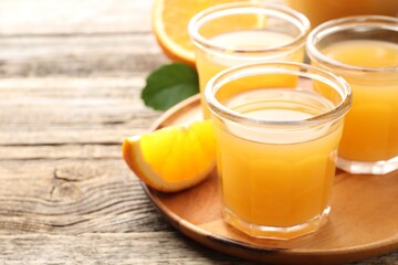 Fresh orange juice and fruits on wooden table, closeup. Space for text