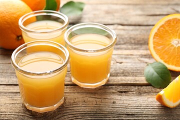 Fresh orange juice and fruits on wooden table, closeup