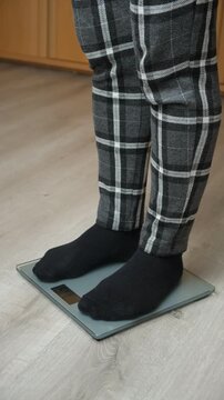 Feet in Black Socks Standing on Digital Bathroom Scales