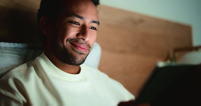 Night, home and happy man with tablet, reading and online news with internet, tech and network. Smile, website blog or person in bedroom, ebook or blue light exposure with app for social media update