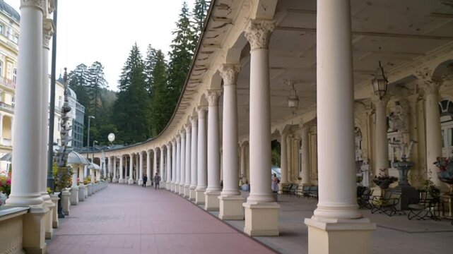 Long white colonnade walkway in historic European spa town, elegant classical architecture with arches and pillars, peaceful travel destination, symmetry, cultural heritage video